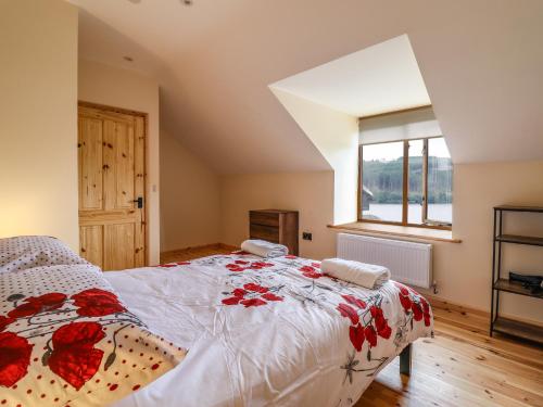a bedroom with a large bed with red flowers on it at Llety Dewi in Oswestry