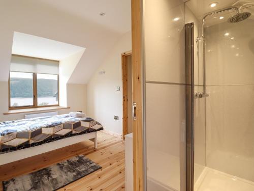 a bedroom with a bed and a shower at Llety Dewi in Oswestry