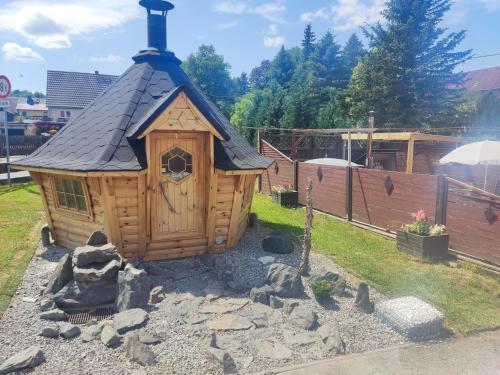 a small wooden house with a black roof at Ferienwohnung 2 am Hofladen Hellendorf in Bad Gottleuba
