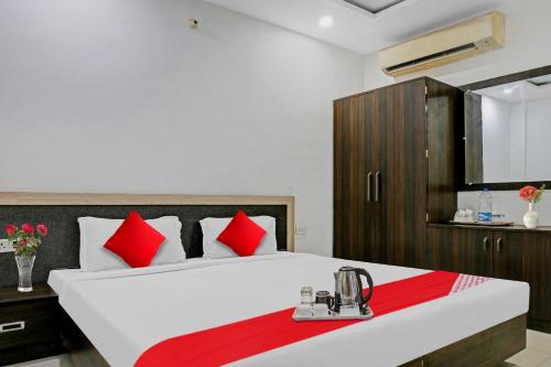 a bedroom with a large white bed with red pillows at Super OYO Flagship 93079 Hotel Paradise in Varanasi