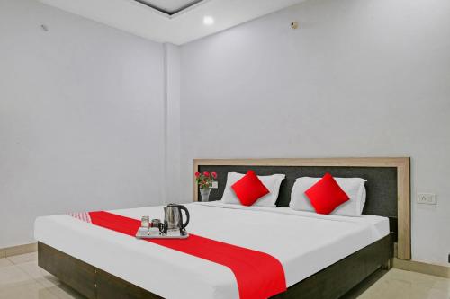 a bedroom with a large bed with red and white pillows at Super OYO Flagship 93079 Hotel Paradise in Varanasi