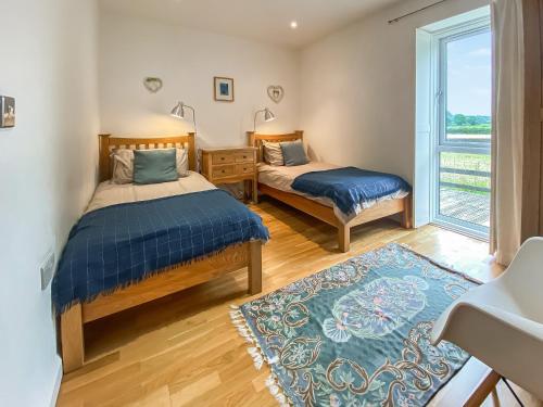 1 dormitorio con 2 camas y ventana en Yew Tree Barn - Hw7737 en Usk
