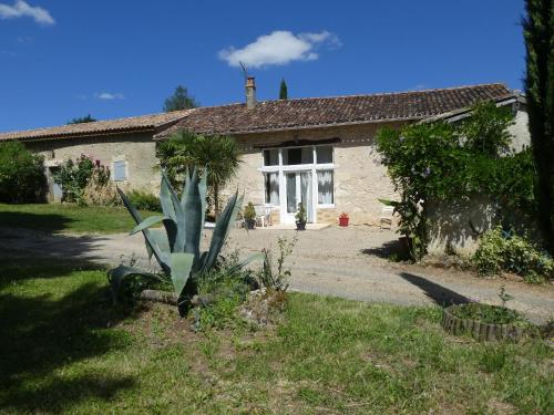 a house with a green plant in front of it at GITE LE PARC in Villamblard