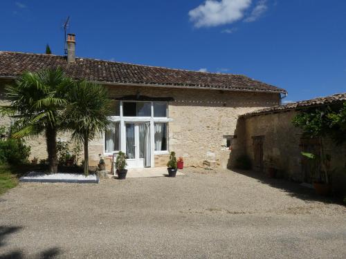 a house with a palm tree in front of it at GITE LE PARC in Villamblard