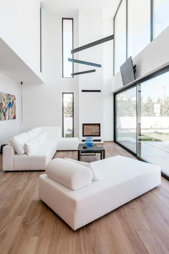 a living room with two white couches and a fireplace at Sunshine Villa in Nafplio