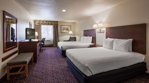 a hotel room with two beds and a television at Best Western Socorro Hotel & Suites in Socorro