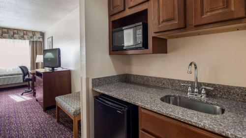 a kitchen with a sink and a microwave at Best Western Socorro Hotel & Suites in Socorro