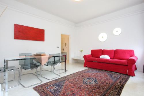 een woonkamer met een rode bank en een tafel bij City Apartments Rialto Market in Venetië