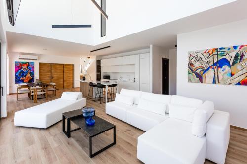 a living room with white couches and a table at Sunshine Villa in Nafplio