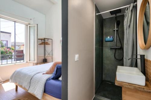- une chambre avec une douche, un lit et un lavabo dans l'établissement Fabuleuse maison/jardin d’architecte proche Paris, à Saint-Denis