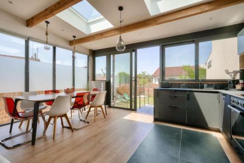 une cuisine et une salle à manger avec une table et des chaises dans l'établissement Fabuleuse maison/jardin d’architecte proche Paris, à Saint-Denis