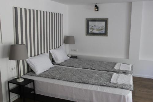 a bed in a white room with at Apartment Sneshka in Ohrid
