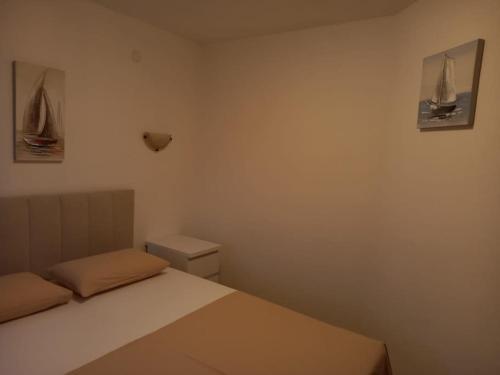 a small bedroom with a bed and a toilet at Apartments Belvedere - A2 in Nečujam