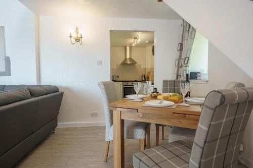 a kitchen and dining room with a table and chairs at Jane Welsh Cottage in Thornhill