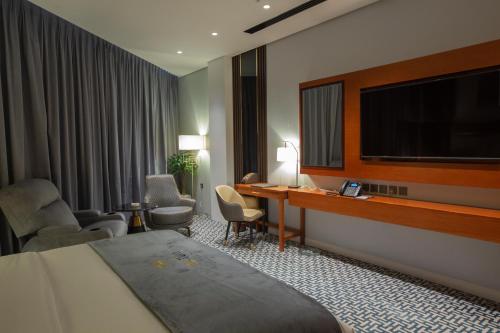 um quarto de hotel com uma cama e uma televisão de ecrã plano em STwin Hotel em Abha
