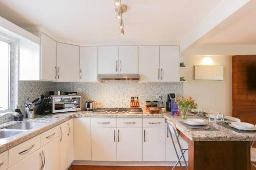 a kitchen with white cabinets and a counter top at Smooth & Vivid Downtown Condo in Ensenada