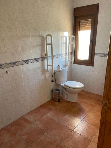 a bathroom with a toilet and a window at Ballestar Hotel Bar & Grill in Barajas de Melo