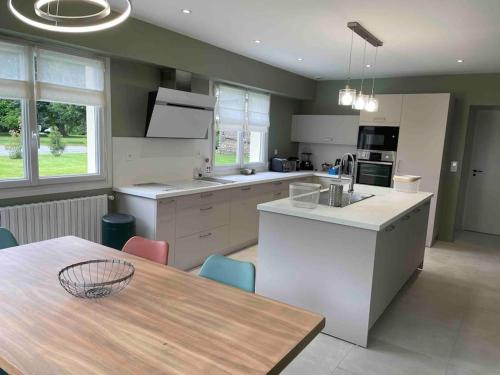 une cuisine avec une table et une salle à manger dans l'établissement MAISON MIQUEU, à Andoins