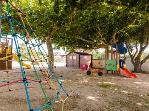 a park with a playground with a swing at Camping Cambrils Caban in Cambrils