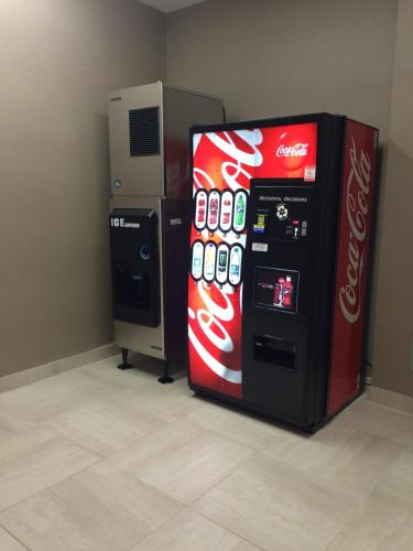 a coca cola vending machine next to a refrigerator at Meridian Inn & Suites Lloydminster in Lloydminster