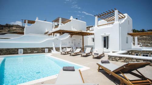 a villa with a swimming pool and chairs at Elia Spirit Villas and Suites by Live&Travel in Elia Beach