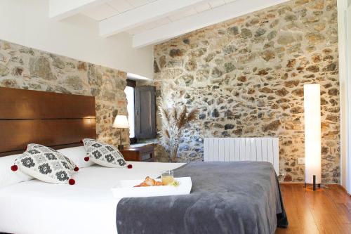 ein Schlafzimmer mit einem Bett und einer Steinmauer in der Unterkunft MONELLS - CASA Rural - CAN FELIP in Monells