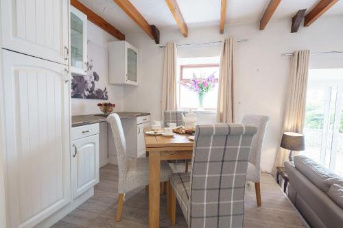 a kitchen with a wooden table and chairs in a room at Drumlanrig Cottage in Thornhill