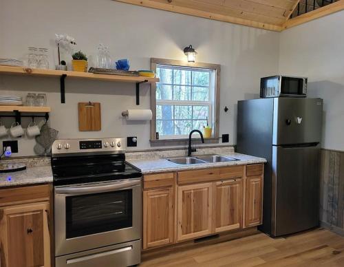 een keuken met een roestvrijstalen koelkast en een wastafel bij Laurel Haven a Modern Cabin Retreat near Gatlinburg in Cosby