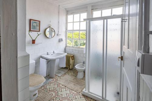 baño con lavabo y aseo y ventana en Casona de la Ribeira Sacra en Puebla del Brollón