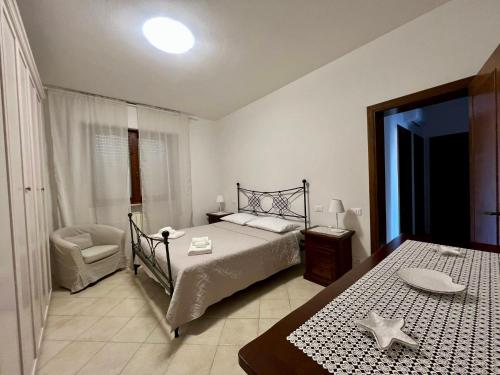 a bedroom with a bed and a table and a chair at Appartamento Sunflower in Viareggio