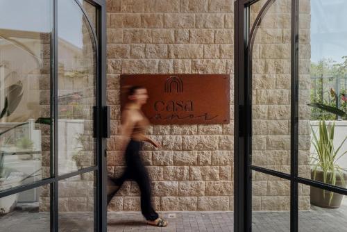 a woman walking out of a glass door at Casa Manor Boutique Hotel in Tivat