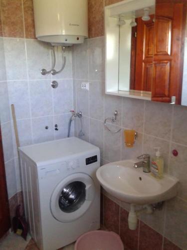 a bathroom with a washing machine and a sink at Apartments Belvedere - A3 in Nečujam
