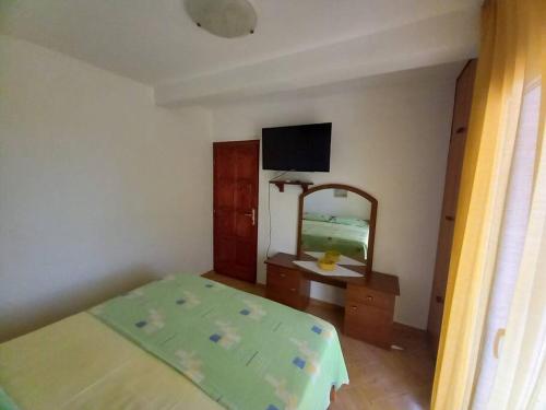 1 dormitorio con cama, espejo y TV en Apartments Belvedere - A3, en Nečujam