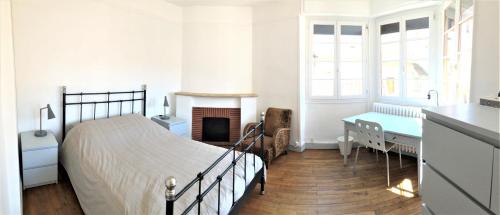 une chambre blanche avec un lit et une cheminée dans l'établissement Appartement familial 3 chambres centre proche Lot, à Cahors