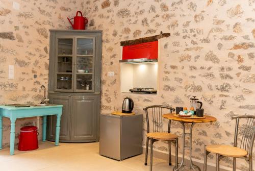 Ydor apartment في هيدرا: مطبخ مع طاولة وطاولة وكراسي