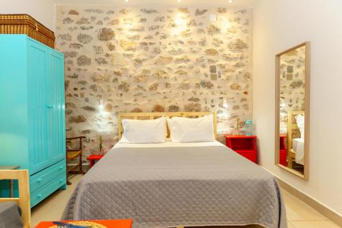 a bedroom with a large bed with a blue cabinet at Ydor apartment in Hydra