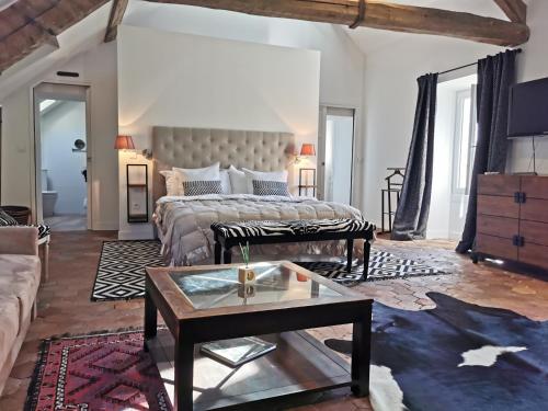 a living room with a bed and a coffee table at Demeure Les Aiglons, Chambres d'hôtes & Spa in Fontainebleau