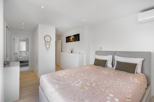 1 dormitorio blanco con 1 cama grande y baño en Family Condo: Urban Retreat w/Parking, AC, Elevator in Great Location, en Lisboa