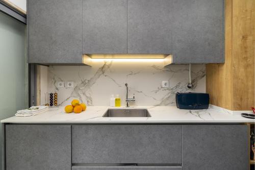 a kitchen with a sink and oranges on the counter at Family Condo: Urban Retreat w/Parking, AC, Elevator in Great Location in Lisbon