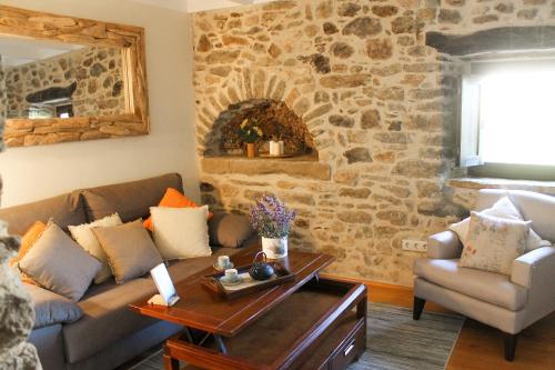 a living room with a couch and a stone wall at MONELLS - CASA Rural - CAN FELIP in Monells