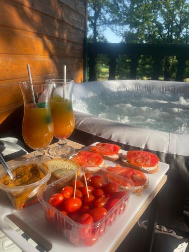 a tray of food and drinks on a table next to a hot tub at Romantique chalet avec sauna et jacuzzi extérieur in Arthon