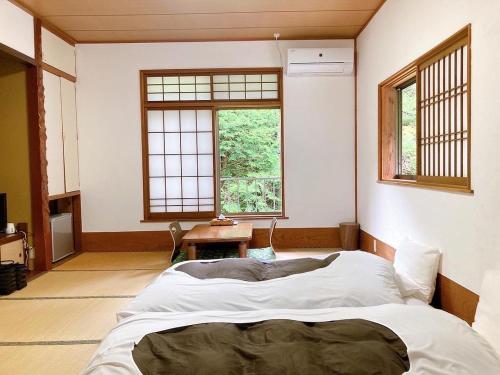 um quarto com uma cama grande num quarto com janelas em YUPOPPO Hakone em Hakone