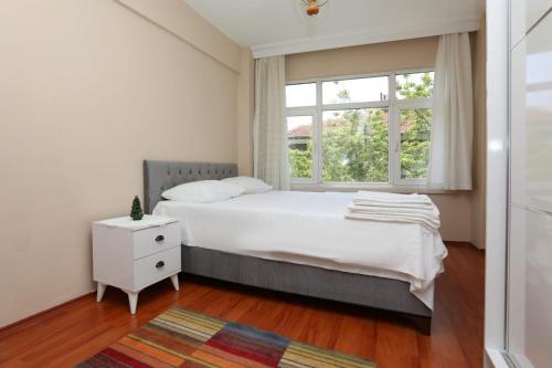a white bedroom with a bed and a window at Flat with Two Living Rooms and Balcony in Uskudar in Istanbul