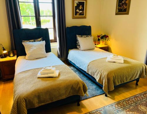 two beds in a room with towels on them at Nostalgia Poganice in Potęgowo