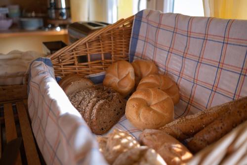 a basket filled with different types of bread on a couch at BurgenLandhaus in Gols