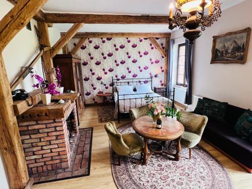 a living room with a table and a fireplace at Nostalgia Poganice in Potęgowo