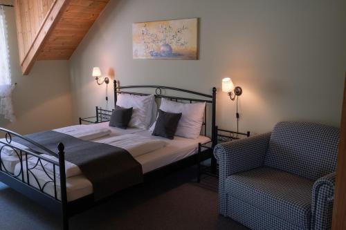 a bedroom with a bed and a chair at BurgenLandhaus in Gols