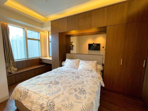 Un dormitorio con una cama grande con una pared de madera. en The Jewel of La Casa, en Surabaya