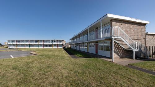 a building with a staircase next to a parking lot at Beaches Chalets in Prestatyn