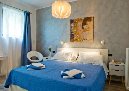 a bedroom with a blue bed with two pillows on it at Como per Voi in Como